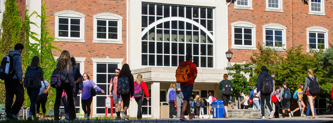 students walking by building on campus