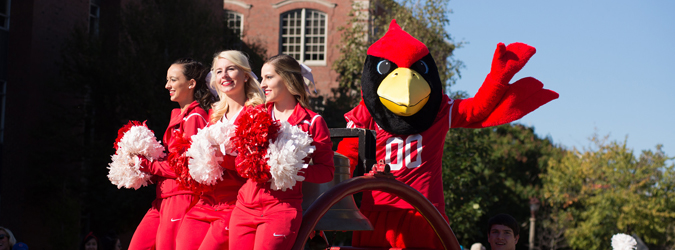 Student life. ISU cheerleaders on cart with reggie redbird during homecoming parade